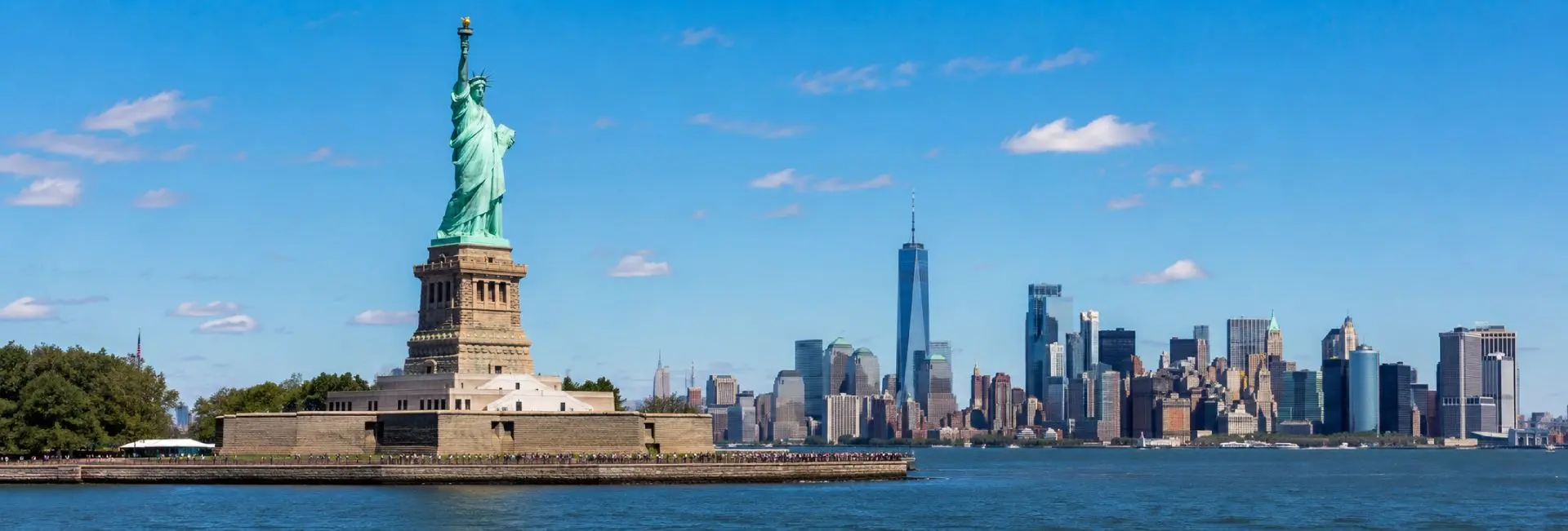 Statue of Liberty overlooking New York Harbor with the Manhattan skyline in the background.