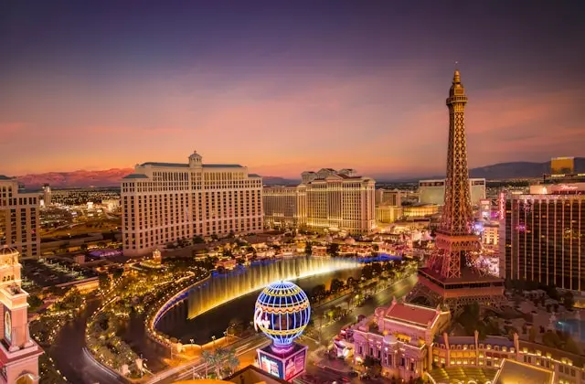 Las Vegas Strip illuminated at sunset with the Eiffel Tower and Bellagio fountains
