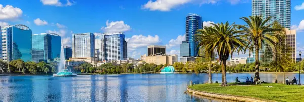 Orlando skyline and Lake Eola Park with fountain and palm trees in downtown Florida