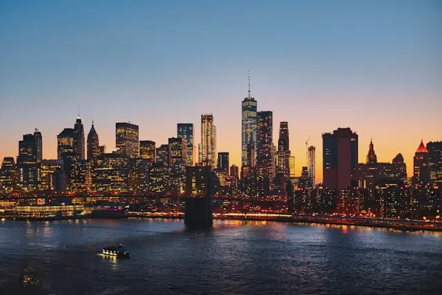 New York City skyline across the Hudson River at sunset with One World Trade Center illuminated